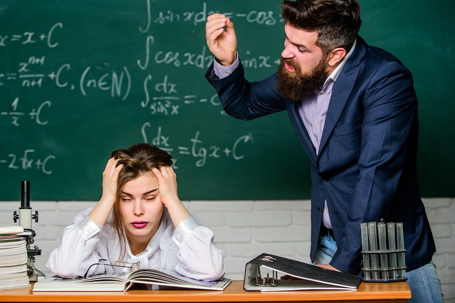 angry male teacher yelling at lgbtq student in classroom