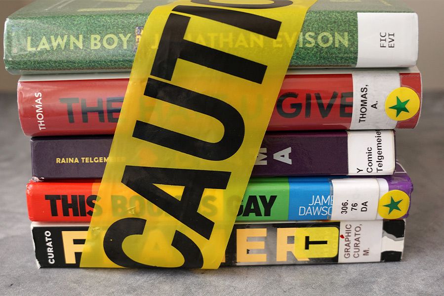 stack of banned books with caution tape wrapped around