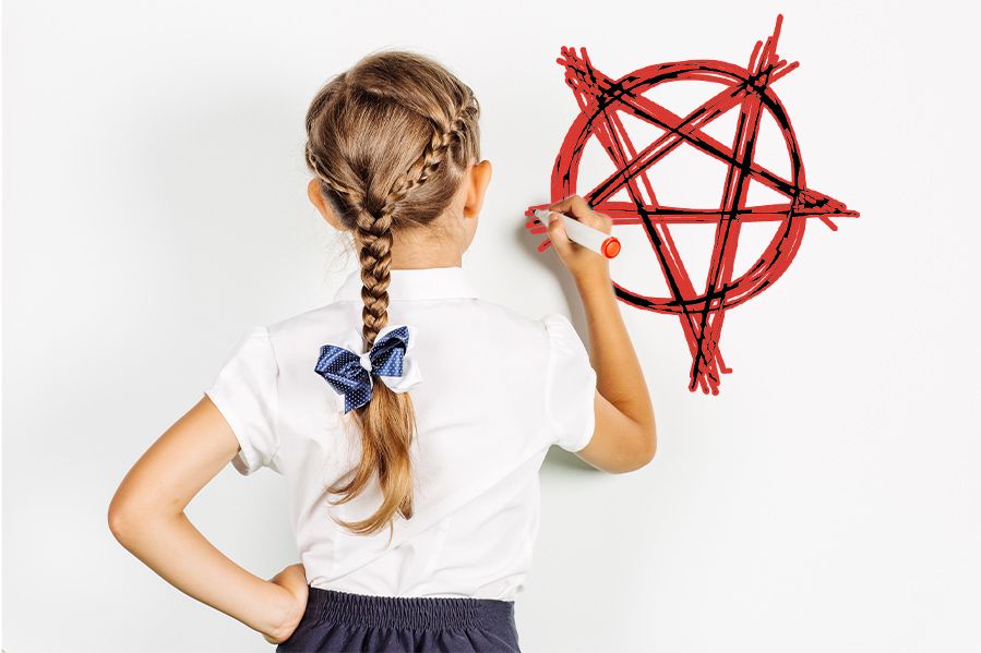 girl writing upside down pentagram on white board