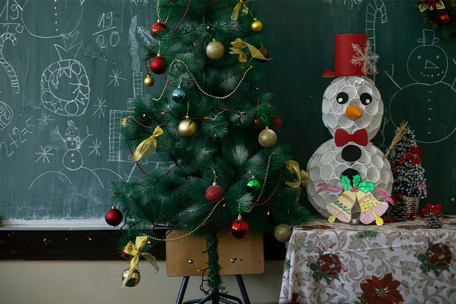 Two brothers are helping to decorate the Christmas tree with red