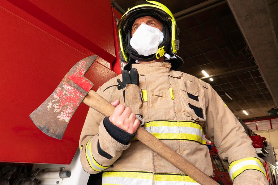 masked firefighter holding fire ax