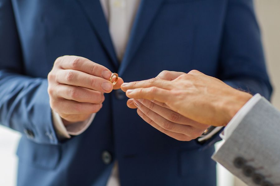 gay grooms exchanging rings during wedding ceremony