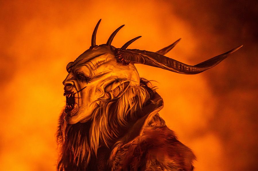 photo of man in krampus costume surrounded by flames