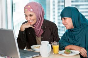 muslim women in office looking at laptop