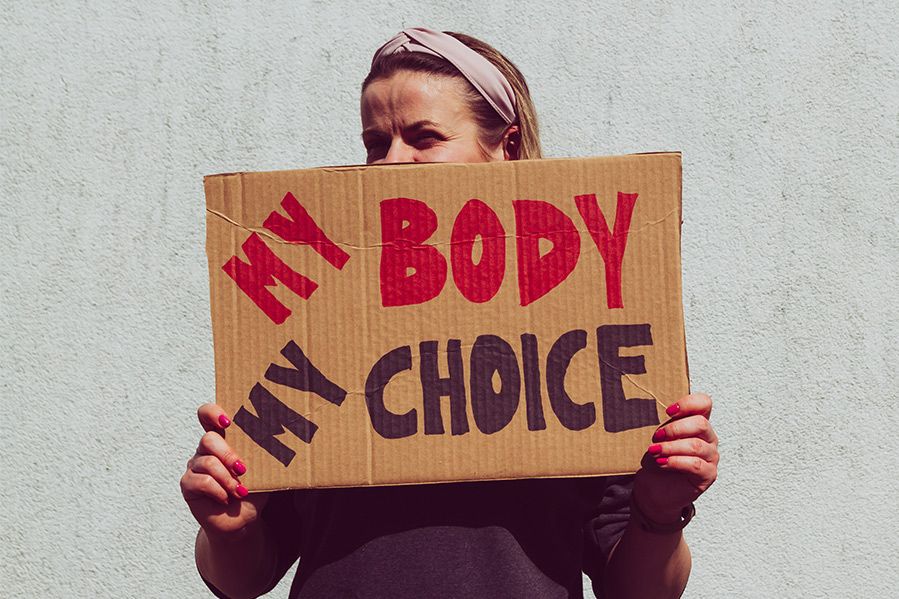 woman holding sign which says my body my choice