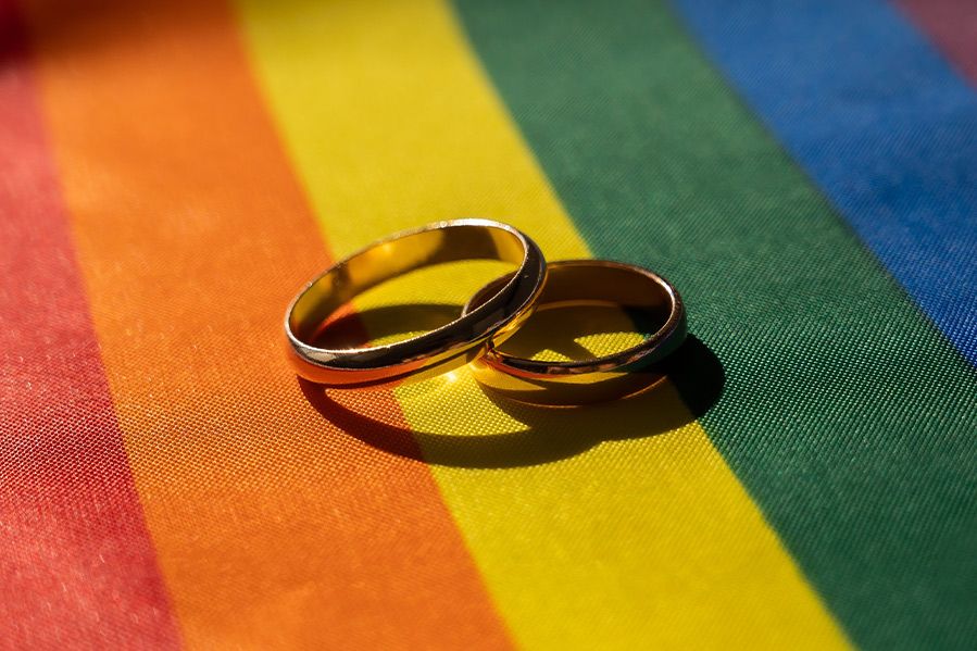 wedding bands atop lgbtq flag