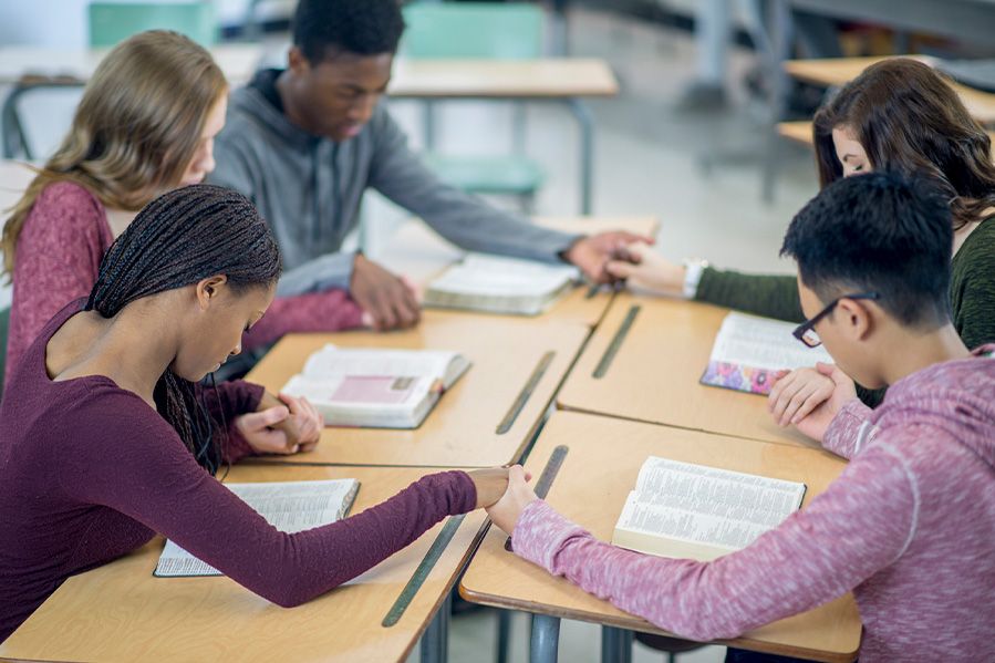 children praying in classroom