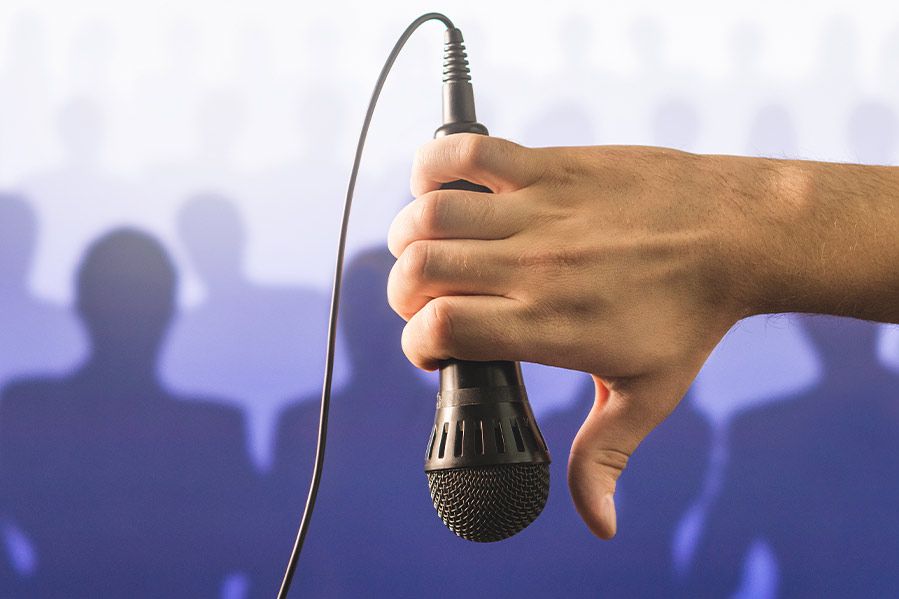 Man making thumbs down while holding microphone