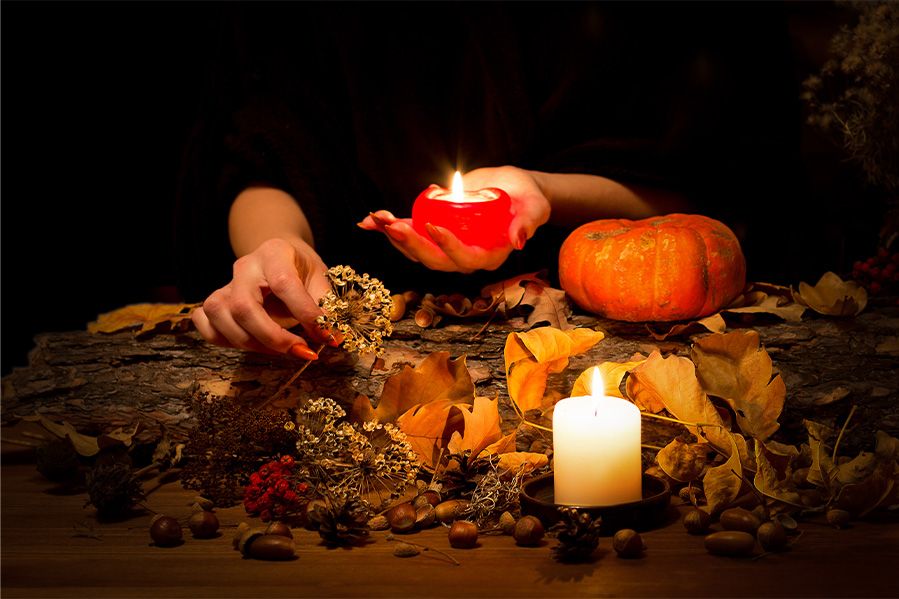 witch casting a hex in woods with lit candles