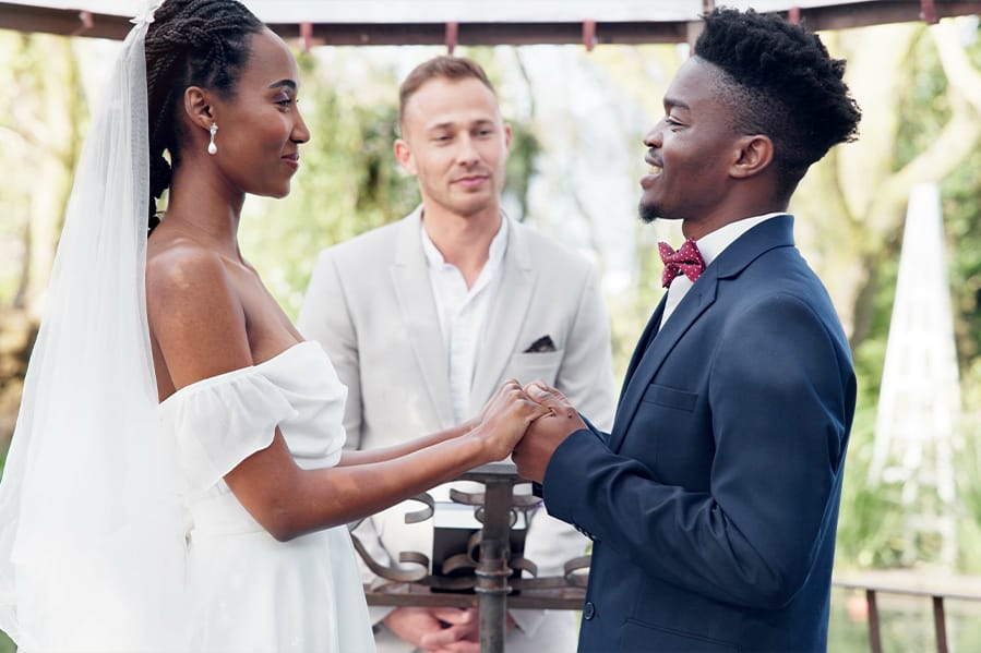 Couple holding hands exchanging vows at the altar.