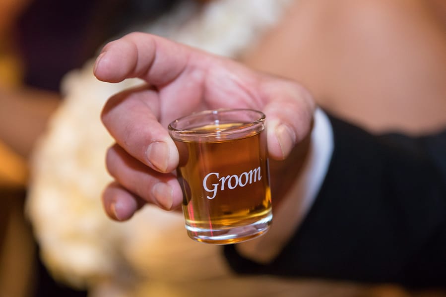 Groom holding a union shot glass. 