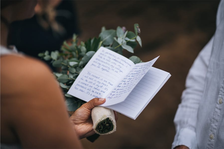 A bride holding a notebook that contains her vows