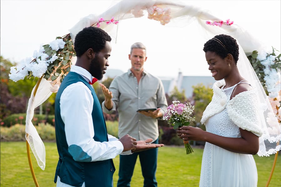 A couple having their ceremony in front of a garden