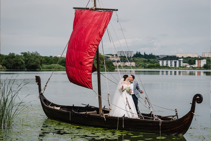 A couple having their ceremony on a viking-style boat in the water